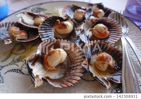 Grilled scallops served on shells, seafood gourmet dish Grilled scallops served on shells, seafood gourmet dish 142308931