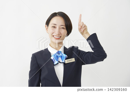 一位中年女員工在白色背景前向上指著。 142309160