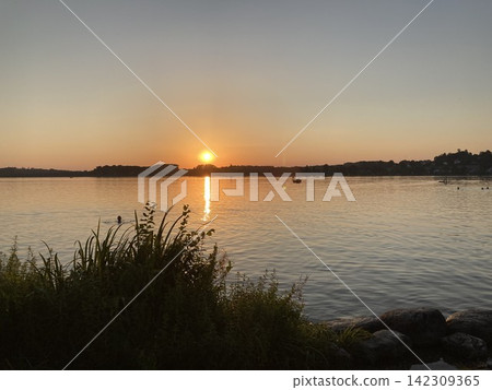 Breathtaking sunset over a calm alpine lake Breathtaking sunset over a calm alpine lake 142309365