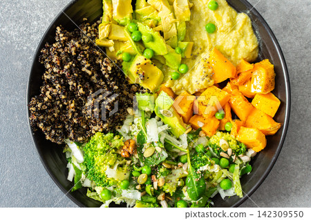 A bowl filled with quinoa, roasted pumpkin, hummus, and a salad of fresh avocado is ready to eat. This meal is gluten free and offers a healthy start to the day A bowl filled with quinoa, roasted pumpkin, hummus, and a salad of fresh avocado is ready to eat. This meal is gluten free and offers a healthy start to the day 142309550