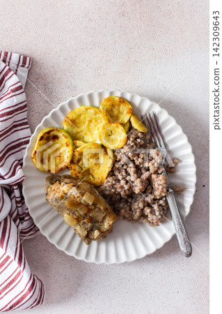 Green buckwheat paired with fried hake, zucchini, and a colorful salad of broccoli, pink radish, and seeds, providing a protein-packed, healthy breakfast to fuel your morning Green buckwheat paired with fried hake, zucchini, and a colorful salad of broccoli, pink radish, and seeds, providing a protein-packed, healthy breakfast to fuel your morning 142309643