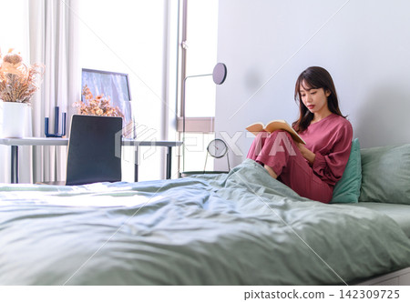 一個女人在床上看書 一個女人在床上看書 142309725