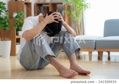 A young man feeling depressed at home A young man feeling depressed at home 142309919