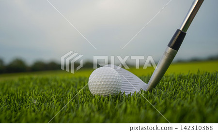 Golf clubs and balls on a green lawn in a beautiful golf course with morning sunshine. Golf clubs and balls on a green lawn in a beautiful golf course with morning sunshine. 142310368