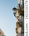 Classic streetlights in an old Italian town, shining brightly against the blue sky. 142310379