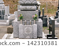 A Japanese gravestone adorned with flowers and a cemetery scene. 142310381