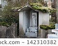 A stone Buddha enshrined in a small moss-covered shrine. 142310382
