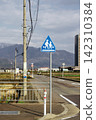 A road sign warning of children crossing the road, with a mountain in the background. 142310384