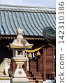 Stone lanterns and guardian lion-dogs line the grounds of a Japanese shrine. 142310386