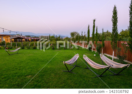 A serene outdoor scene featuring a tranquil garden area with vibrant green grass A serene outdoor scene featuring a tranquil garden area with vibrant green grass 142310792