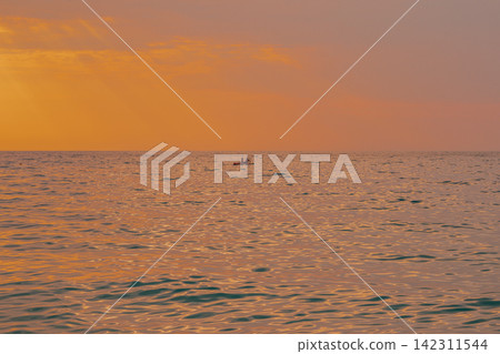 Distant view of couple on stand up paddleboard SUP in calm sea waters during golden warm sunset in Lefkada island Greece horizontal stock photo Distant view of couple on stand up paddleboard SUP in calm sea waters during golden warm sunset in Lefkada island Greece horizontal stock photo 142311544