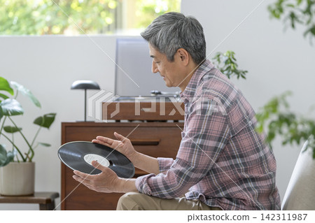 A man in his 60s holding a record A man in his 60s holding a record 142311987