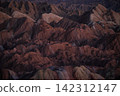 Red rock faces and eroded land 142312147
