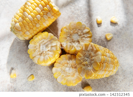 Fresh corn cobs with kernels on gray background Fresh corn cobs with kernels on gray background 142312345
