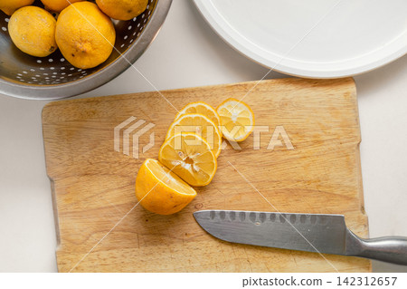Fresh Garden Lemons Sliced for Drying on a Wooden Cutting Board Fresh Garden Lemons Sliced for Drying on a Wooden Cutting Board 142312657