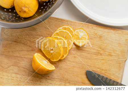 Fresh Garden Lemons Sliced for Drying on a Wooden Cutting Board Fresh Garden Lemons Sliced for Drying on a Wooden Cutting Board 142312677
