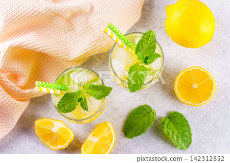 Top view of refreshing homemade lemonade. Fresh mint, lemon slices, ice in glasses, cold beverage Top view of refreshing homemade lemonade. Fresh mint, lemon slices, ice in glasses, cold beverage 142312852