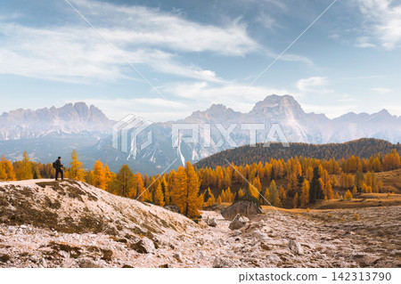 Hiker standing on a snowy ridge overlooking Monte Cristallo 142313790