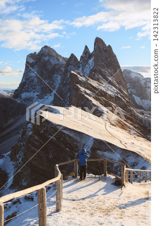 Photographer admiring the snow-covered peaks of Seceda Photographer admiring the snow-covered peaks of Seceda 142313822