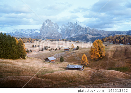 Sassolungo rises above rolling meadows and mountain huts on Alpe di Siusi Sassolungo rises above rolling meadows and mountain huts on Alpe di Siusi 142313832