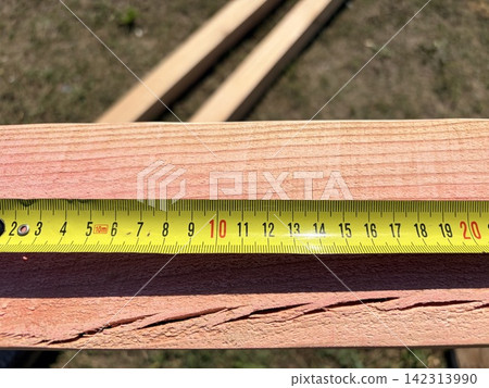 worker using a tape measure to measure a log worker using a tape measure to measure a log 142313990
