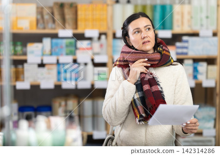Woman with family therapists prescription visits pharmacy and suffers from sore throat Woman with family therapists prescription visits pharmacy and suffers from sore throat 142314286