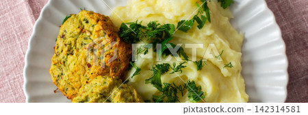A plate holds mashed potatoes topped with finely chopped herbs beside turkey meatballs, creating a nutritious meal option for breakfast or lunch at home, banner A plate holds mashed potatoes topped with finely chopped herbs beside turkey meatballs, creating a nutritious meal option for breakfast or lunch at home, banner 142314581