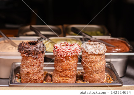 Gourmet chimney cakes with colorful toppings at dessert counter Gourmet chimney cakes with colorful toppings at dessert counter 142314654