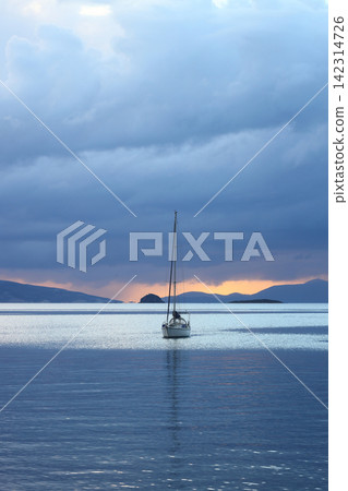Alone sailboats at sunset. Atmospheric seascape with reflection 142314726