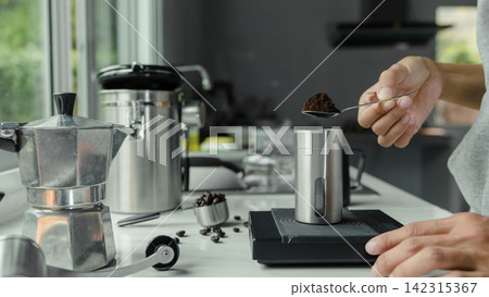 powder coffee on a stainless spoon with hand people pour Roasted coffee for espresso coffee into the cup with equipment digital scale tool . brewing coffee at kitchen home. preparation drink powder coffee on a stainless spoon with hand people pour Roasted coffee for espresso coffee into the cup with equipment digital scale tool . brewing coffee at kitchen home. preparation drink 142315367