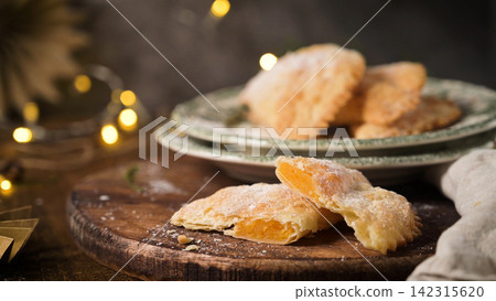 Sweet pastries filled with pumpkin jam on a wooden board Sweet pastries filled with pumpkin jam on a wooden board 142315620
