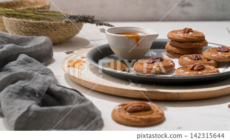 Caramel Thumbprint Cookies with Pecans and Sea Salt on a Metal Tray Caramel Thumbprint Cookies with Pecans and Sea Salt on a Metal Tray 142315644