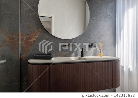 Bathroom vanity featuring round mirror with natural light from the curtain Bathroom vanity featuring round mirror with natural light from the curtain 142315658