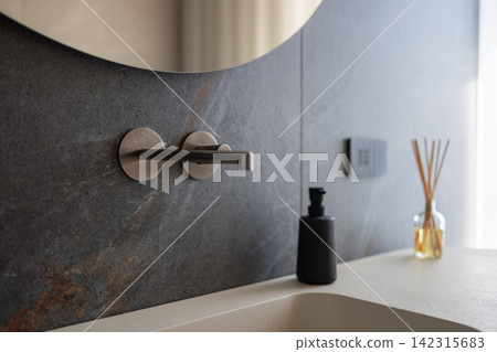 Wall mounted bathroom faucet above an integrated basin as an interior detail Wall mounted bathroom faucet above an integrated basin as an interior detail 142315683