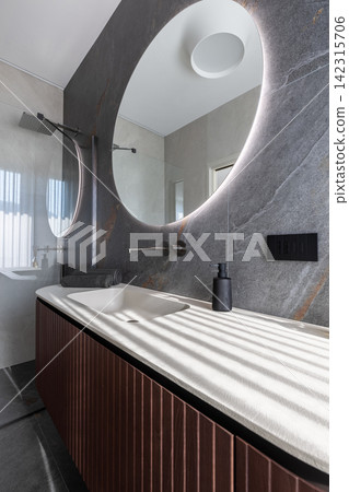 Sunlit bathroom vanity featuring an integrated basin under controlled side light Sunlit bathroom vanity featuring an integrated basin under controlled side light 142315706