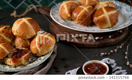 Freshly baked hot cross buns with jam on a decorative plate Freshly baked hot cross buns with jam on a decorative plate 142315798