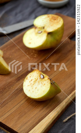 Sliced Apple with Cinnamon on a Cutting Board Sliced Apple with Cinnamon on a Cutting Board 142315922