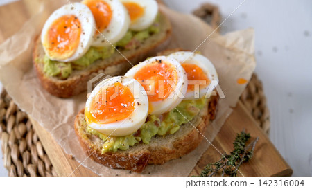 Soft Boiled Eggs on Smashed Avocado Toast with Black Pepper and Herbs Soft Boiled Eggs on Smashed Avocado Toast with Black Pepper and Herbs 142316004