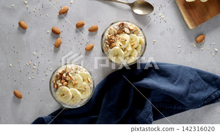 Overnight oats with banana slices and almonds in glass jars Overnight oats with banana slices and almonds in glass jars 142316020