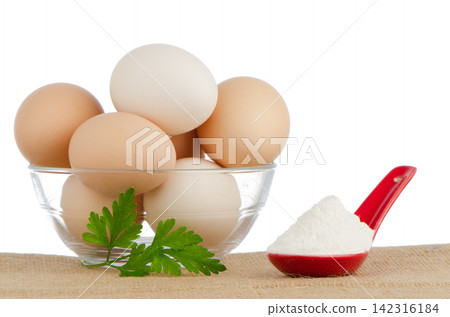 Brown eggs on brown and red ceramic spoon with white powder Brown eggs on brown and red ceramic spoon with white powder 142316184