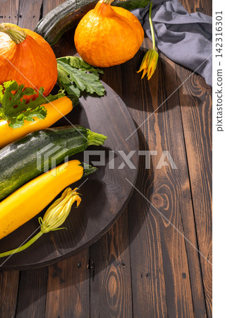 Freshly harvested organic squash and zucchini on wooden table Freshly harvested organic squash and zucchini on wooden table 142316301