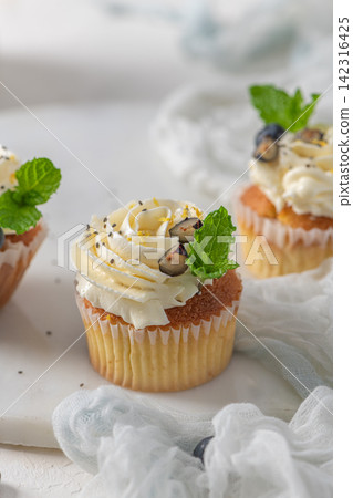 Fresh Blueberry Cupcakes with White Buttercream Frosting and Mint Garnish Fresh Blueberry Cupcakes with White Buttercream Frosting and Mint Garnish 142316425