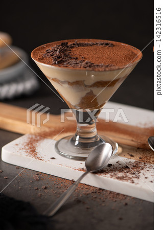 Individual Tiramisu Dessert in stemmed cocktail Glass with Cocoa Powder and Chocolate Shavings Individual Tiramisu Dessert in stemmed cocktail Glass with Cocoa Powder and Chocolate Shavings 142316516