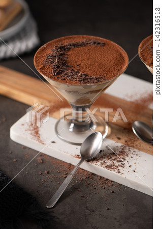 Tiramisu Dessert Served in a Crystal Glass with Cocoa Powder and Chocolate Shavings Tiramisu Dessert Served in a Crystal Glass with Cocoa Powder and Chocolate Shavings 142316518
