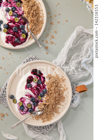 Healthy yogurt bowls with fresh blueberries and crunchy cereal topping Healthy yogurt bowls with fresh blueberries and crunchy cereal topping 142316553