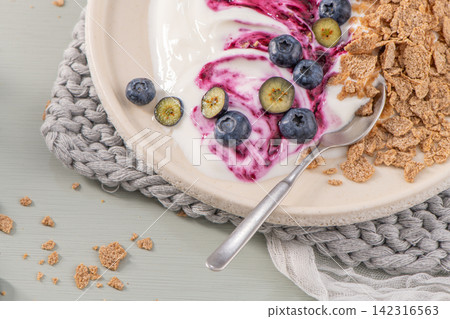 Healthy breakfast bowl with creamy yogurt, blueberry swirl, fresh berries, and whole-grain cereal flakes Healthy breakfast bowl with creamy yogurt, blueberry swirl, fresh berries, and whole-grain cereal flakes 142316563