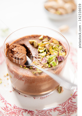 A decadent chocolate dessert, beautifully topped with vibrant pistachios A decadent chocolate dessert, beautifully topped with vibrant pistachios 142316659
