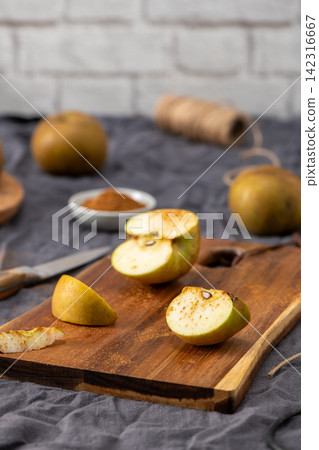 Sliced apple with cinnamon on a cutting board Sliced apple with cinnamon on a cutting board 142316667