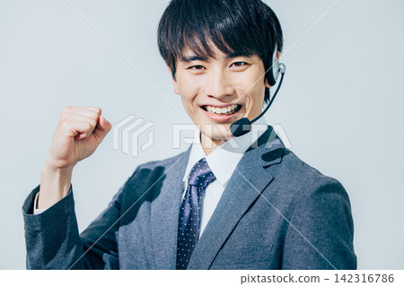 一名身穿西裝、戴著耳機的男子。 142316786