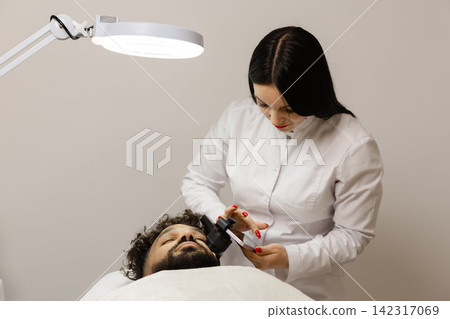 Dermatologist examining patient's skin for mole checkup Dermatologist examining patient's skin for mole checkup 142317069